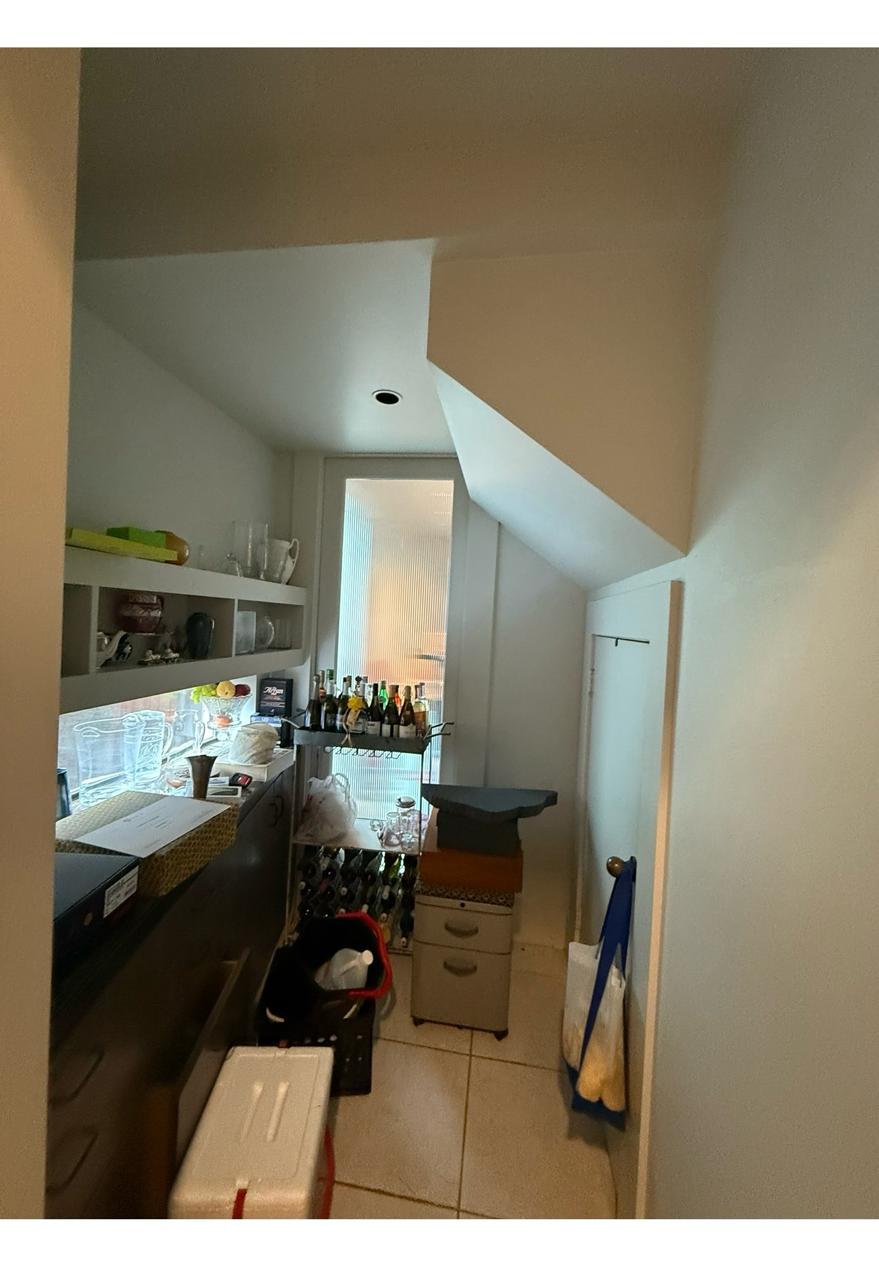 Butler's pantry and wet bar with open shelving under a sloped ceiling