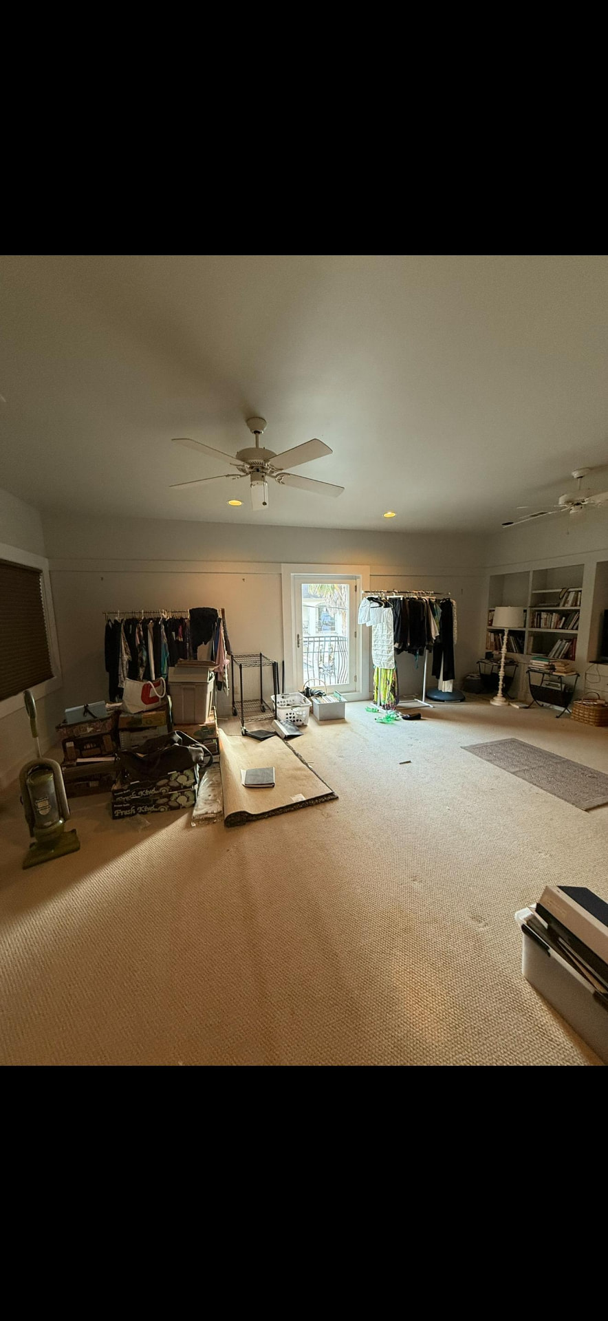Upstairs bedroom suite with ceiling fans, built-in shelving, and balcony door